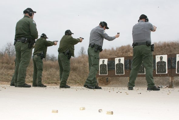 agents shooting pistols at targets as part of completing firearms qualifications