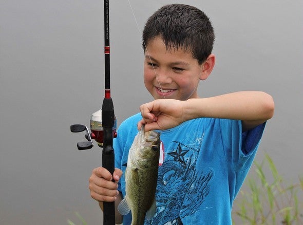 A young angler poses with a fish he caught at a Missouri pond.