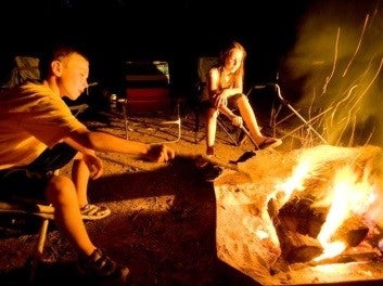 two kids around a campfire