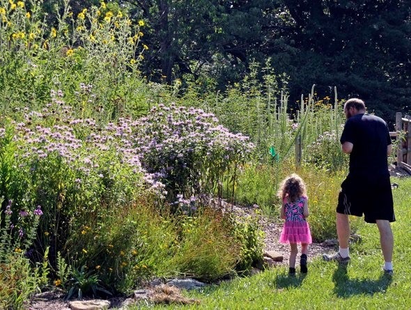 dad and daughter looking flowers