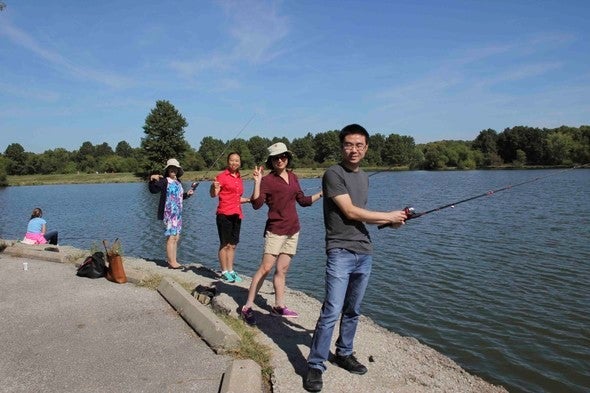 A family poses for a picture while fishing at a lake