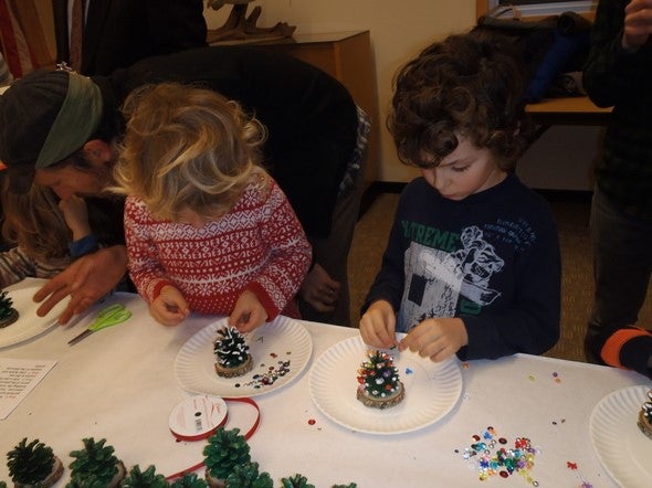 two kids make nature-themed crafts at a table