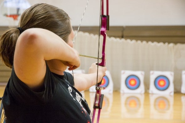 teacher learning archery skills by shooting compound bow