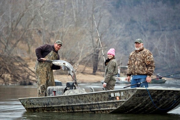 three snaggers on boat with one paddlefish