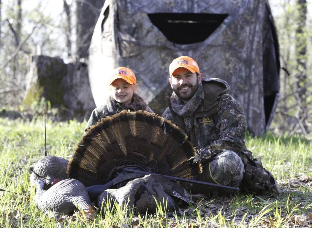 Jake Hindman and his daughter pose with a harvested turkey