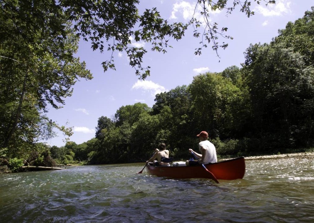 two people canoeing on river
