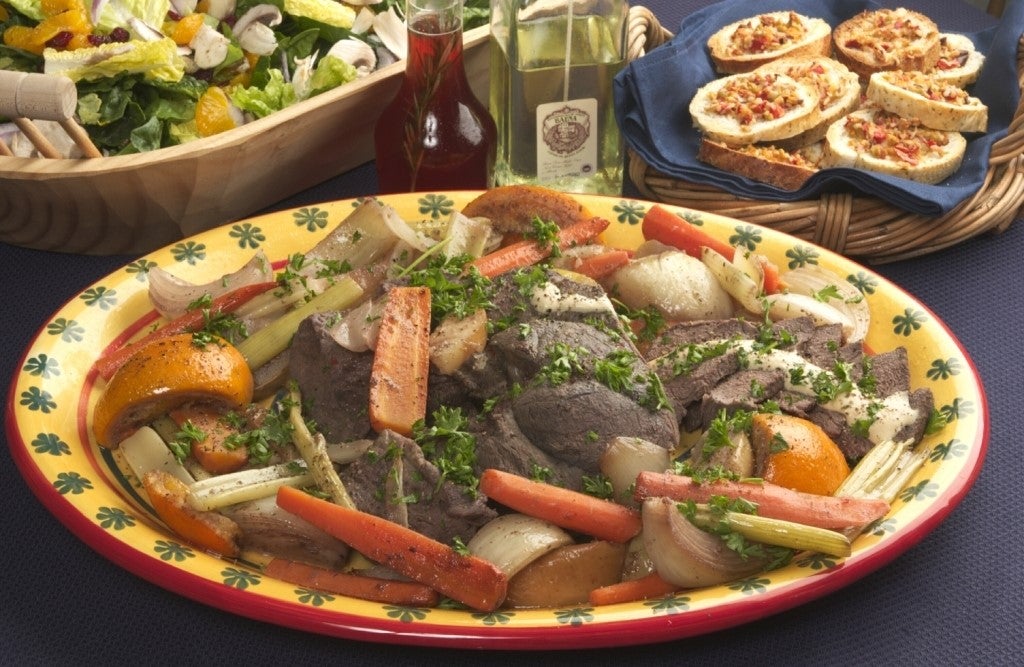 A venison dish with vegetables on a dinner table.