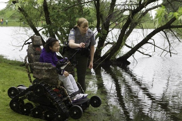 agent helps woman fish from wheelchair