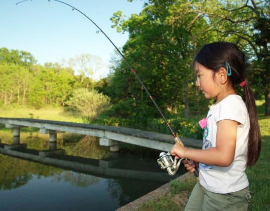 Girl fishing on the edge of a lake