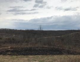 A burned area in an open field 