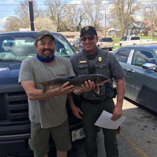 Harvey Smith holding white sucker with Conservation Agent Jeff Harris.