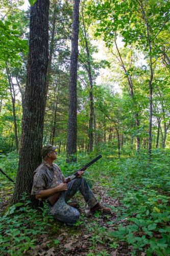 A hunter next to a tree