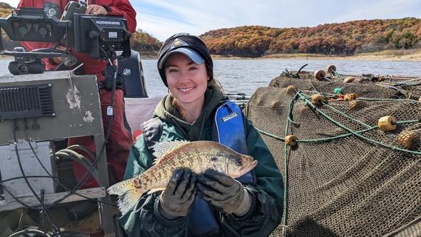 Biologist holds crappie on boat