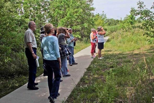 Group of people look for birds on a nature walk