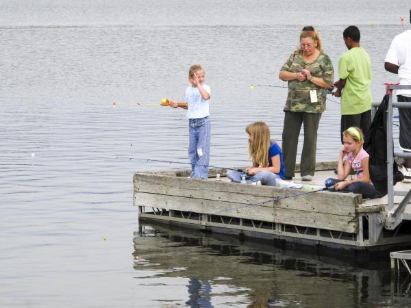 A family fishes off a dock at Little River conservation area