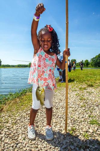 A young angler shows her catch