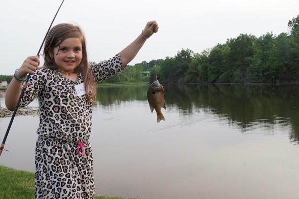 Little girl holding a fish she caught.