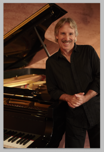 John Nilsen posing in front of a grand piano