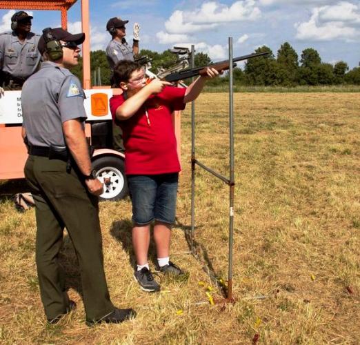 MDC staff supervises a boy shooting a shotgun