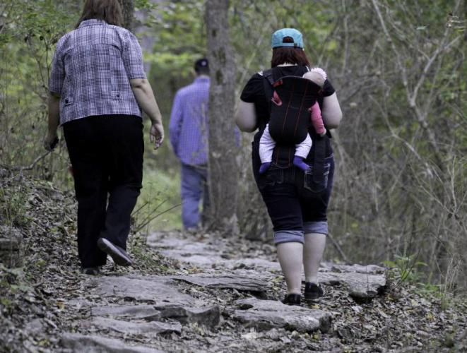 A woman with her baby go on a hike.