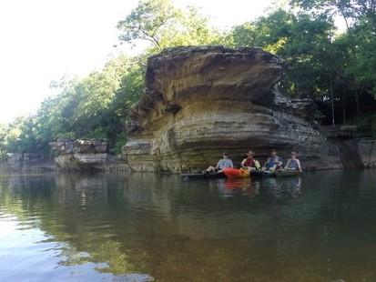 four canoeists and kayakers pose in their watercrafts on the Big Piney River
