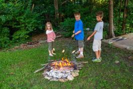 kids over a campfire cooking