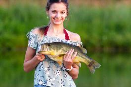 young girl holding up a fish