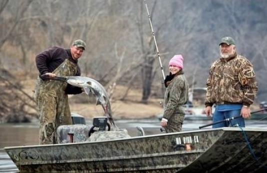 three snaggers on boat with one paddlefish
