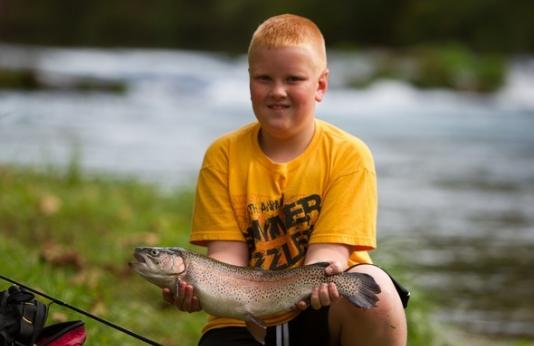 Boy holds large rainbow trout