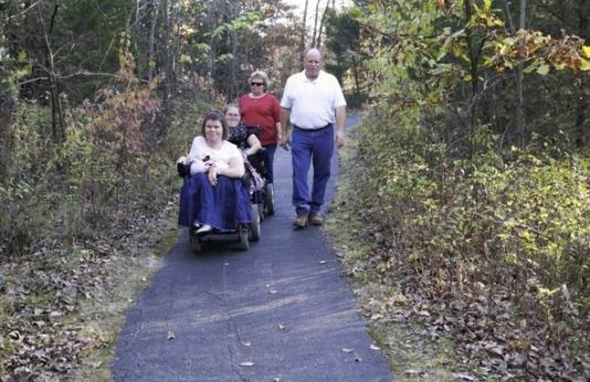 A group takes a nature walk on a paved trail.