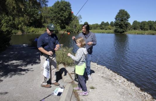 MDC Staff member helps mom and daughter fish
