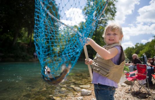 Child Fishing with Fish In Net