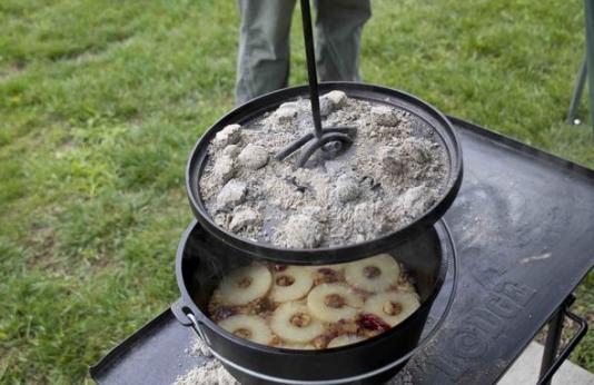 Pot full of food cooking over a campfire.