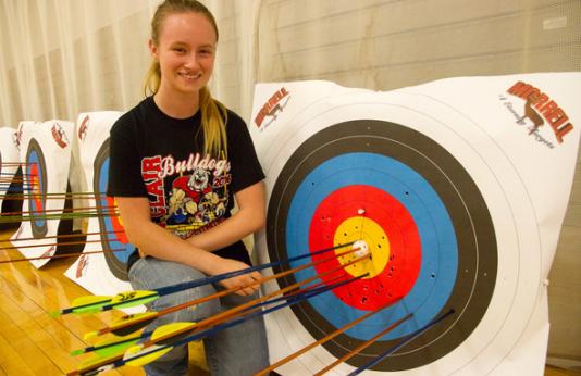 MoNASP archer poses with her arrows in the target.