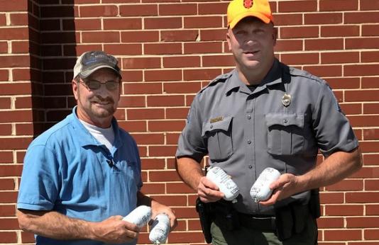 Paul Arnold with Mississippi Lime Company and Conservation Agent Rob Sulkowski pose with Share the Harvest donations.