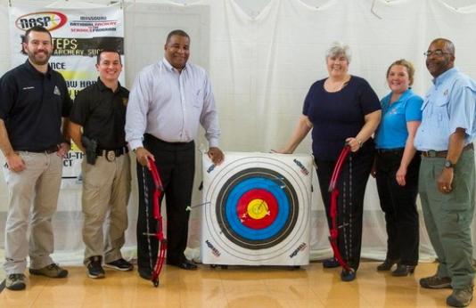 group of people posed with archery equipment