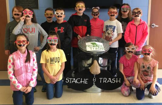students pose with winning trashcan