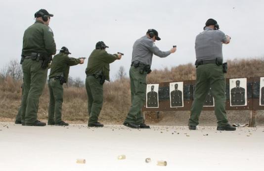 agents shooting pistols at targets as part of completing firearms qualifications
