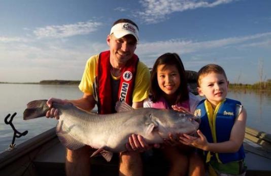Dad and kids with catfish