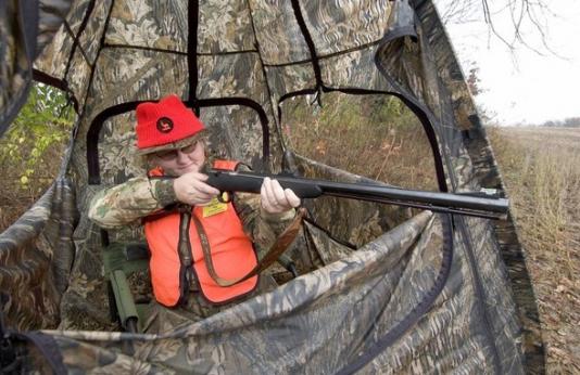 deer hunter shooting from blind