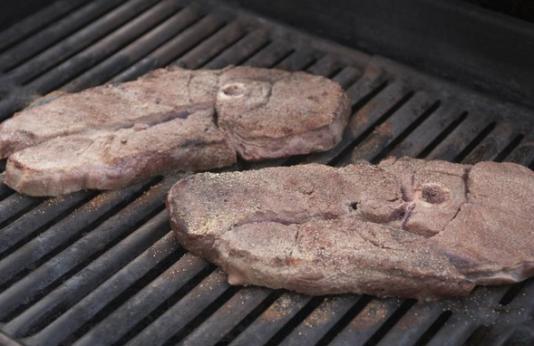 two venison steaks on grill