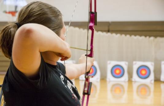 teacher learning archery skills by shooting compound bow