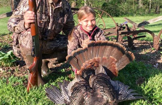 girl and dad with girl's harvested turkey