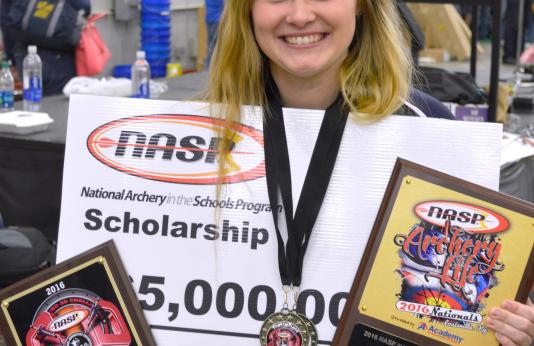 Shelby Winslow holding her awards an prizes form the national tournament.