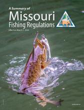 A smallmouth bass bites on a lure on the cover of the 2023 fishing regulation summary.